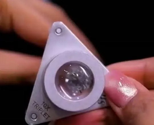 A 10x triplet loupe held over a diamond