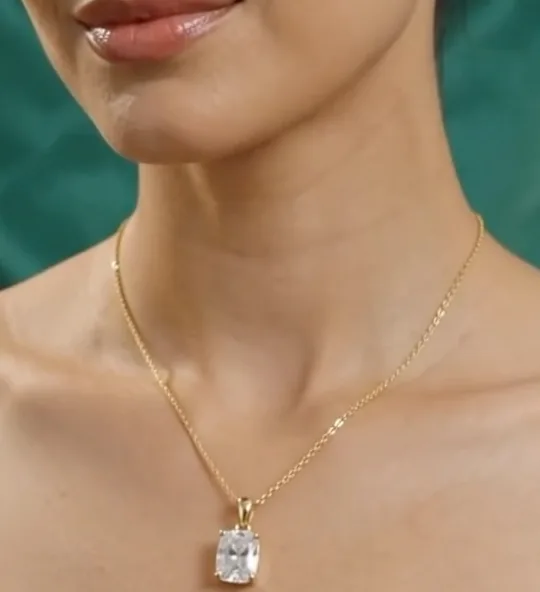 A one carat emerald-cut solitaire pendant on a gold chain